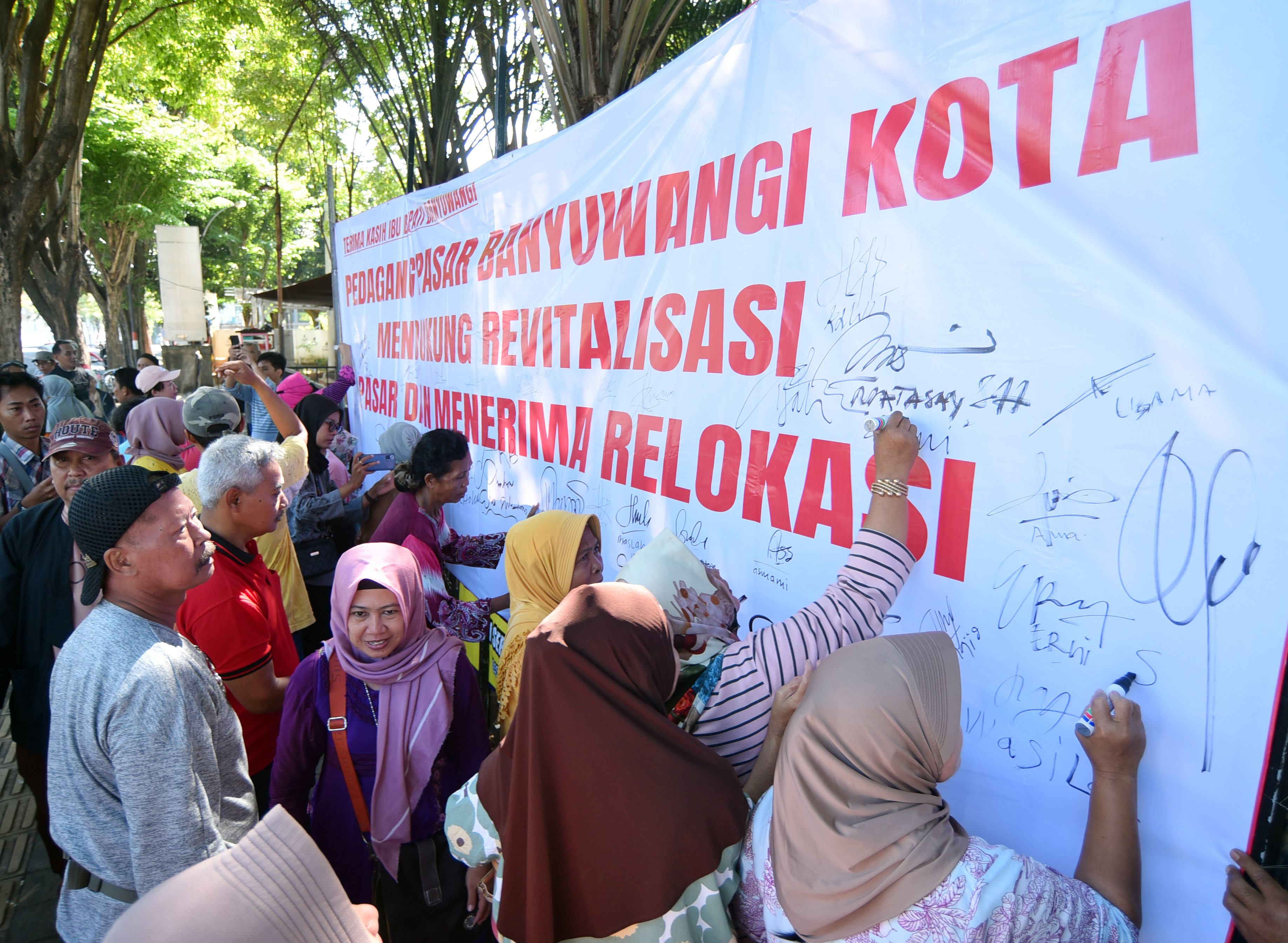 sejumlah pedagang membuhbuhkan tanda tangan di atas spandung yang bertuliskan dukungan revilitasi pasar banyuwangi
