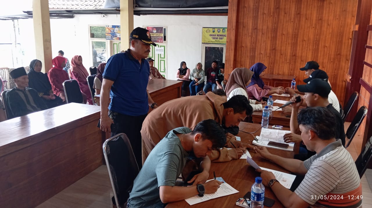 PEDULI: Koordinator keamanan kebun PT Bumisari Koko Darmanto (pakai topi) memantau pemberian tali asih kepada warga di Pendopo Kantor Desa Pakel, Kecamatan Licin Jumat (31/5)