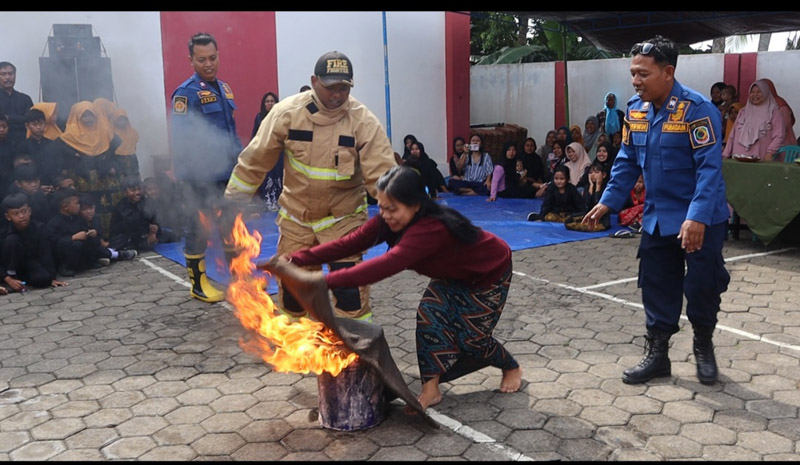 SIGAP: Salah satu peserta berupaya memadamkan kobaran api dalam rangkaian pelatihan dan simulasi kebakaran di Desa Gumuk, Kecamatan Licin.