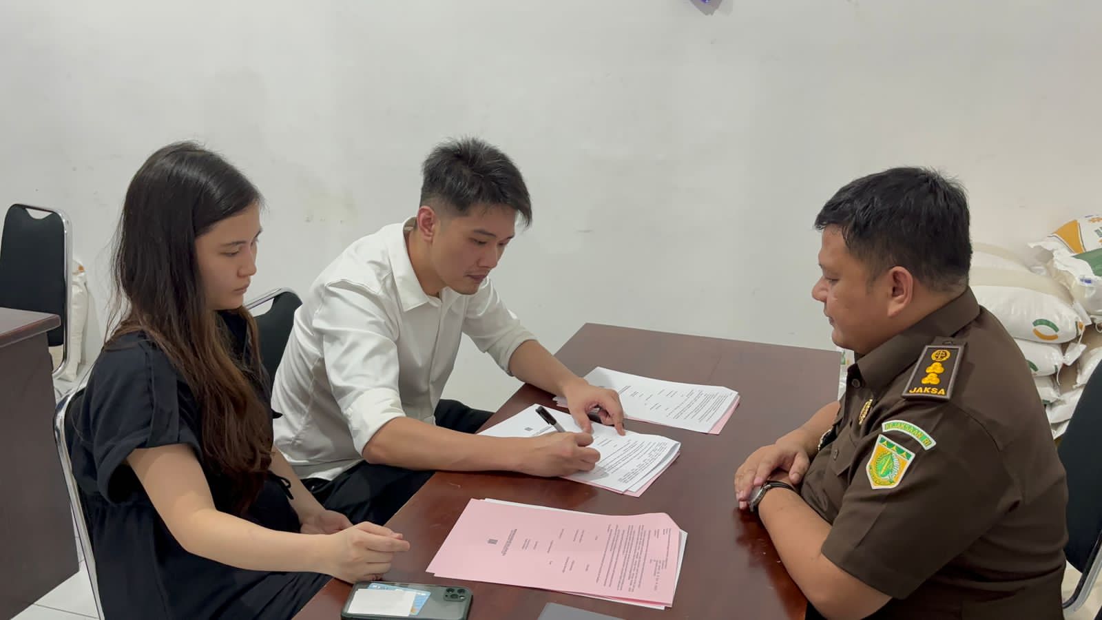 RESTORATIVE JUSTICE: Sharon Milan dan Willy Soedargo meneken surat perdamaian disaksikan Kasi Pidum Ahmad Budi Mukhlis di kantor Kelurahan Kertosari, Jumat lalu (31/5).
