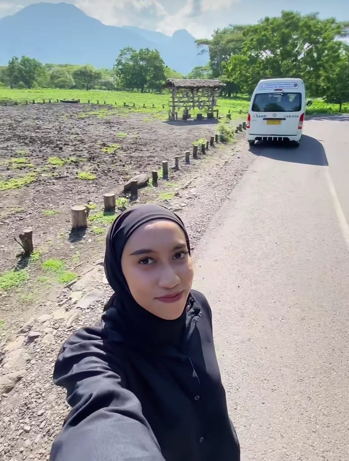 Wisatawan yang menumpang Bus Damri berfoto di savana Bekol, Taman Nasional Baluran, Situbondo.