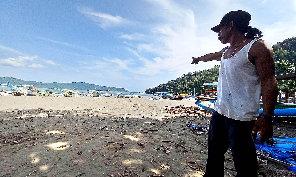 MEGATHRUST: Joko Prasetyo menunjukkan posisi celah teluk yang memicu hantaman gelombang tsunami yang menerjang Pantai Rajegwesi, Sarongan, Pesanggaran, semakin kuat pada tahun 1994 silam.
