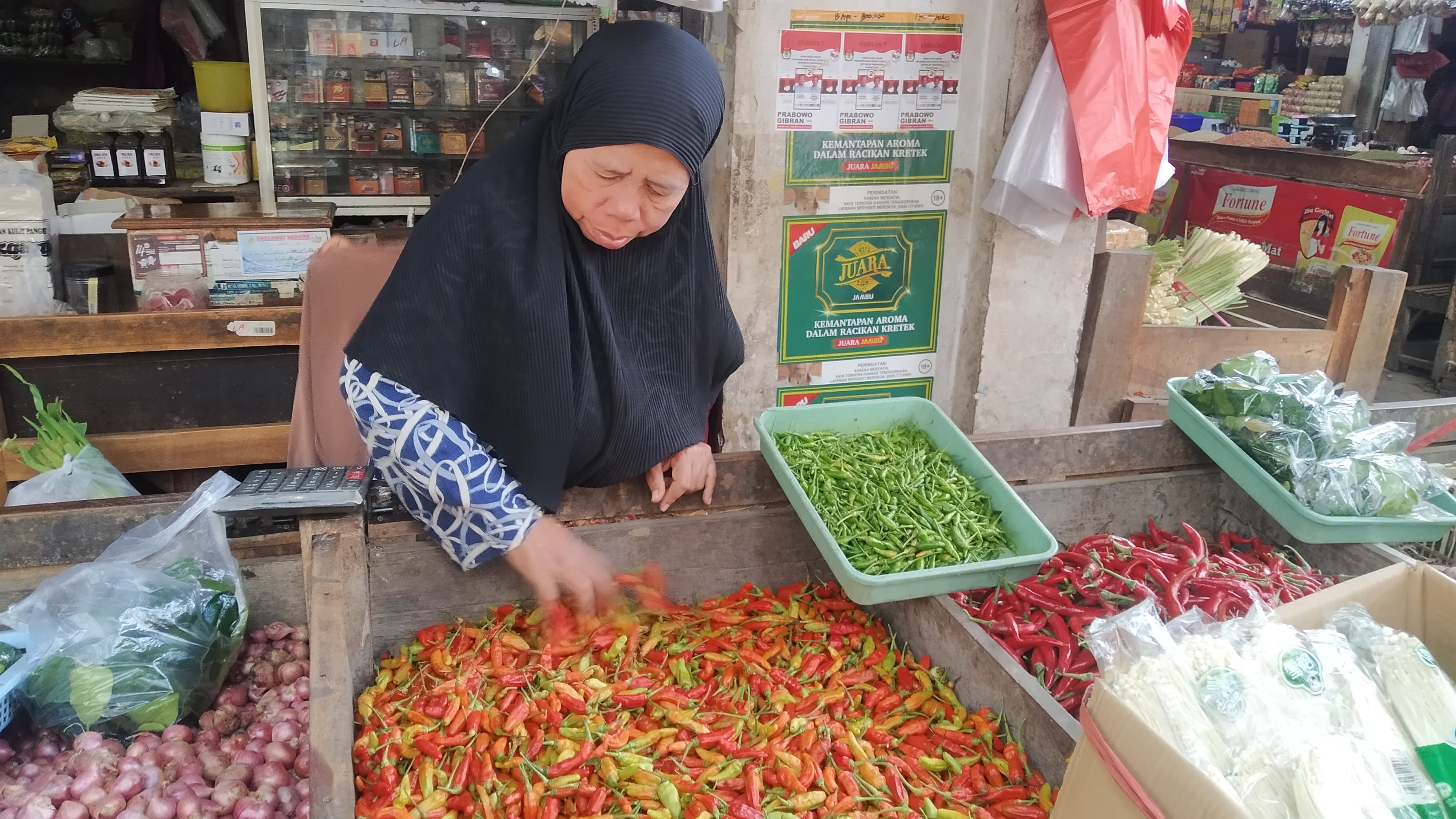  HARGA NAIK: Hajiti merapikan cabai dagangannya di Pasar Induk Genteng 1, Desa Genteng Kulon, Kecamatan Genteng Senin (10/6).  