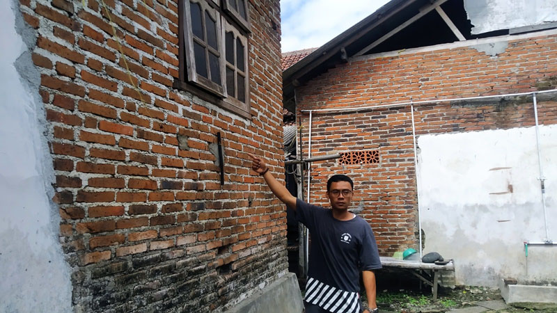 JALAN MASUK: EW menunjukka jendela yang dibuat pelaku masuk ke rumah NT untuk rudapaksa di Desa/Kecamatan Tegalsari Senin (10/6).