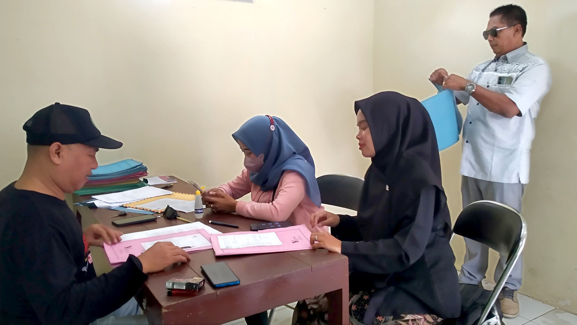 MENGUMPULKAN BERKAS: Hartoyo (kiri) menerima persyaratan administrasi pendaftar Pantarlih di kantor sekretariat PPS Desa/Kecamatan Gambiran Kamis (13/6)