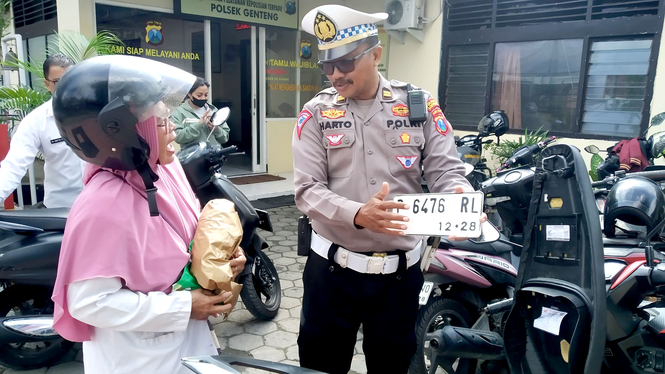 PAKAI LAMA: Kanit Lantas Polsek Genteng Iptu Suharto (kanan) meminta salah satu pemotor yang terjariang razia Hartini memasang plat nomor baru Rabu (12/6).