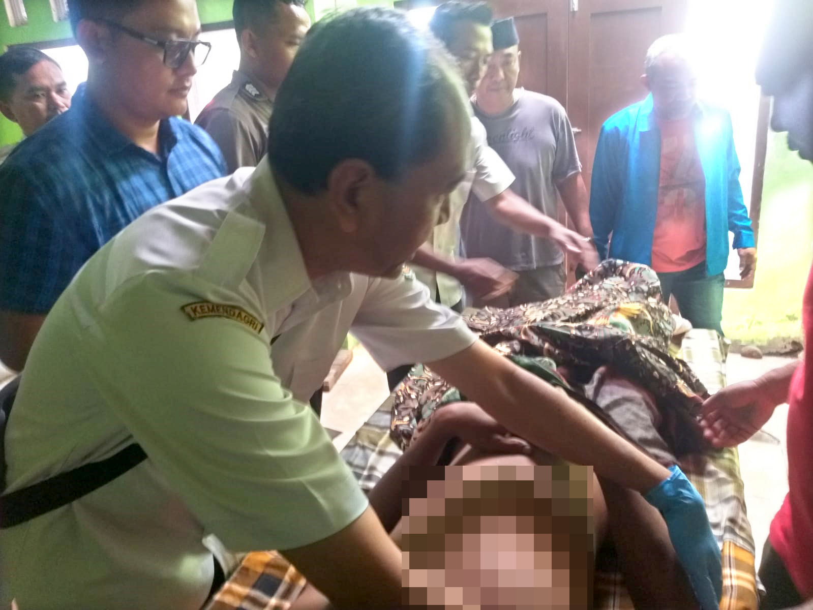 TRAGIS: Jenazah AD setelah dievakuasi warga dari lokasi gantung diri diperiksa oleh petugas kesehatan pada Rabu (12/6).