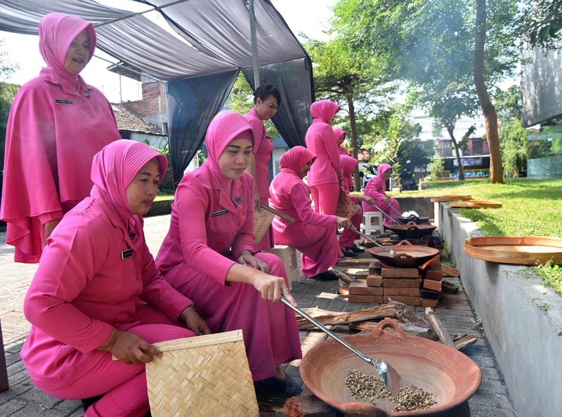 TAMBAH PENGALAMAN: Sejumlah anggota Bhayangkari Polresta Banyuwangi belajar menyangrai kopi di halaman gedung Grha Pena, kantor JP-RaBa Jumat (14/6).