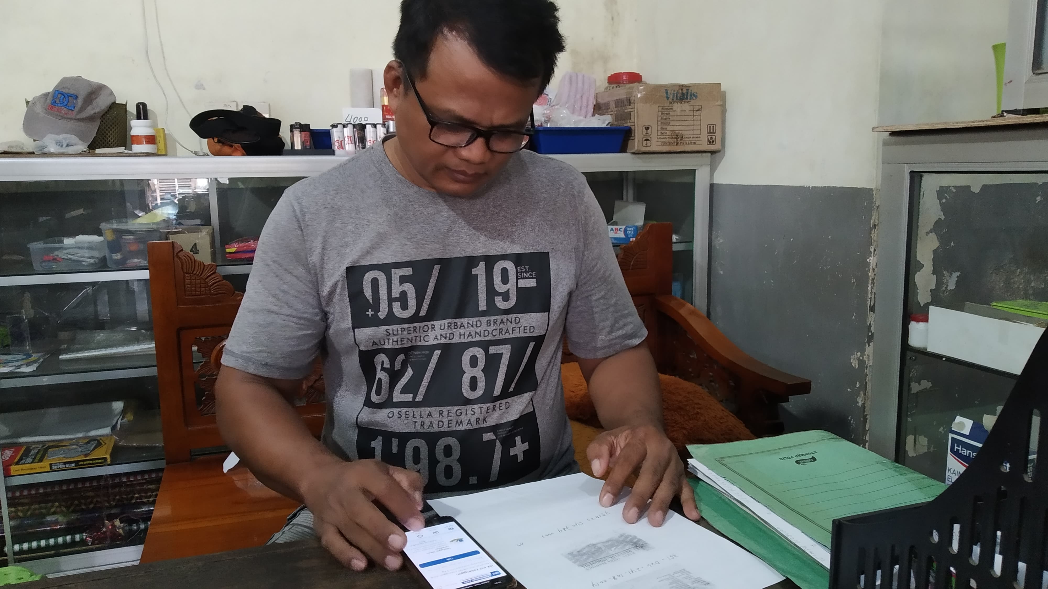 MENDATA: Adi Riyanto menginput data pembeli di tokonya Dusun Blokagung, Desa Karangdoro, Kecamatan Tegalsari Jumat (14/6).