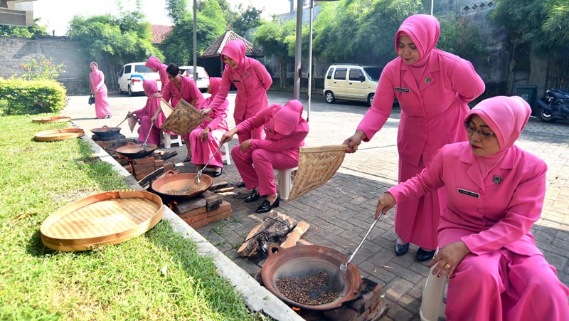 KERJA SAMA: Sejumlah personel Bhayangkari praktik menyangrai kopi di halaman kantor JP-RaBa pada Jumat (14/6) lalu.