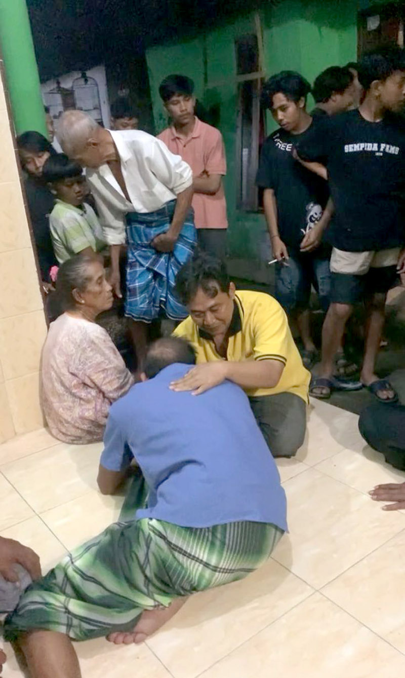 KEBOAN: Kepala Desa Aliyan Agus Nurbani Yusuf (kaus kuning) merangkul Sapuan yang kesurupan leluhur meminta ritual adat keboan Aliyan digelar pada Selasa (18/6) malam.
