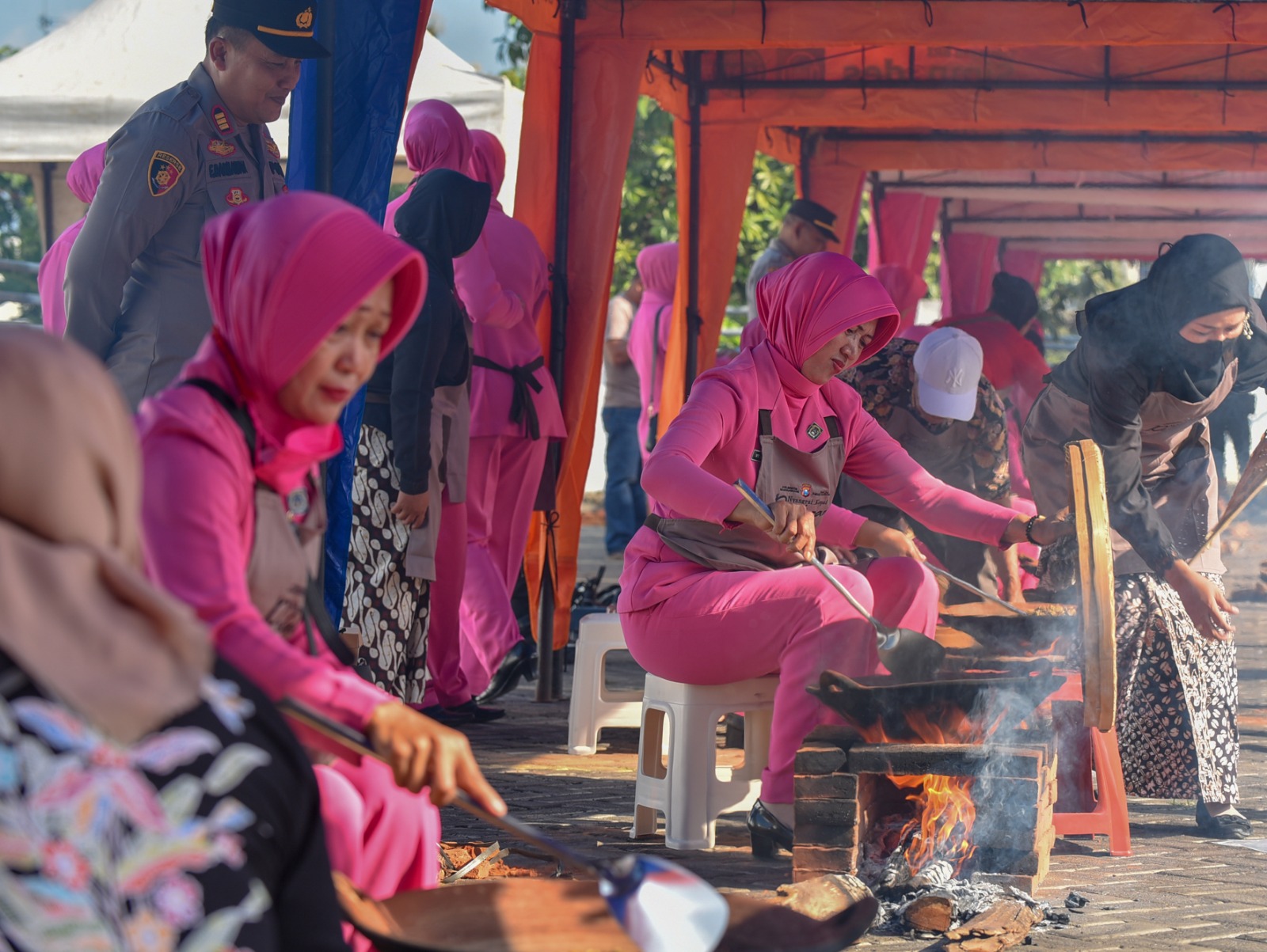 Ibu bhayangkari dari jajaran Polresta Banyuwangi menyangrai kopi serentak di Event Sangrai Kopi Pelataran Polresta Banyuwangi bersama Jawa Pos Radar Banyuwangi  Sabtu (22/6)