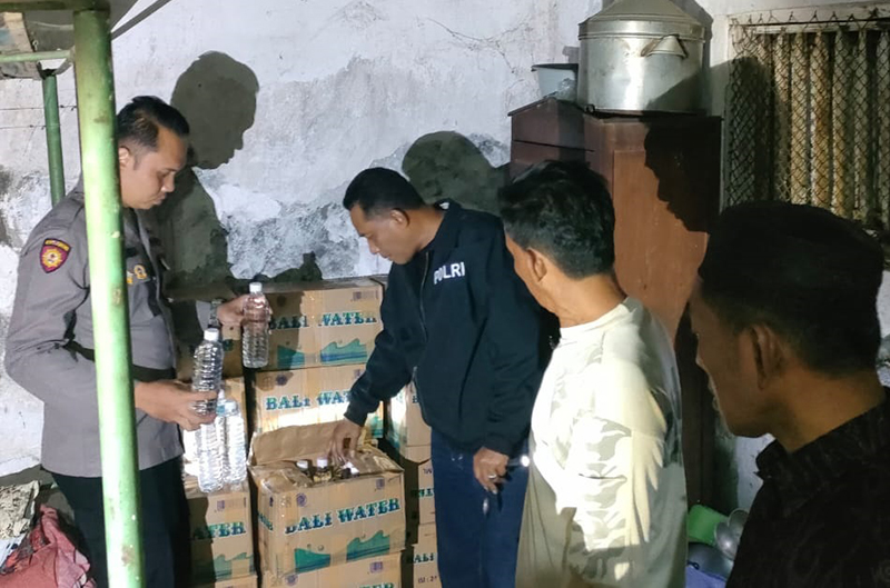 TERCIDUK: Anggota Polsek Besuki mengamankan barang bukti minuman keras (Miras) di rumah milik Eva Wulandari, 31, warga Desa Pesisir, Kecamatan Besuki, Situbondo, Sabtu malam (22/6).