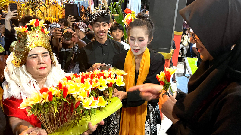 TUGAS PERDANA: Isni memberikan kembang dermo kepada Bupati Ipuk Fiestiandani dalam rangkaian ritual seblang di Kelurahan Bakungan, Kecamatan Glagah, Minggu malam (23/6).