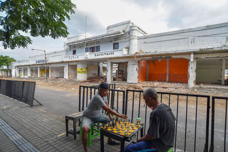 DISISAKAN BAGIAN DEPAN: Dua orang bermain catur dengan latar belakang bangunan lama Pasar Banyuwangi yang tidak lama lagi akan direvitalisasi, Selasa (25/6).&nbsp;&nbsp;