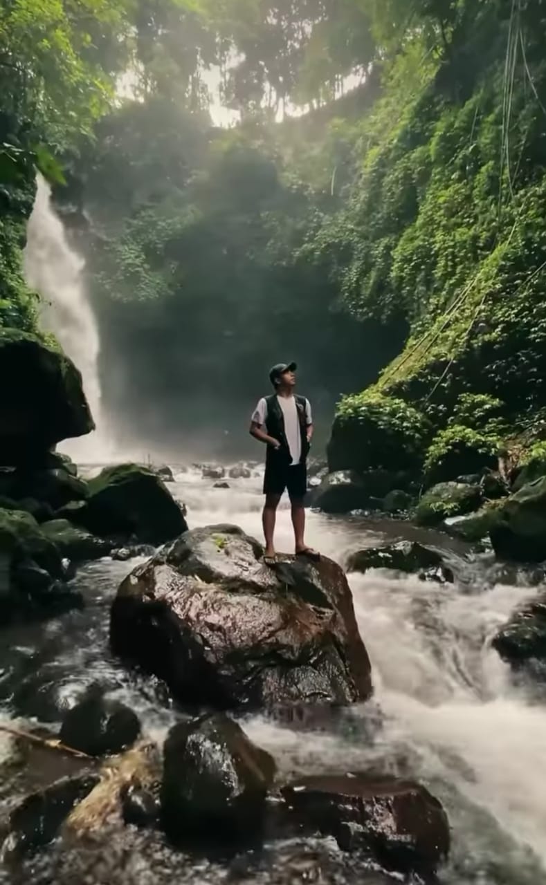Pengunjung berfoto di depan air terjun Jagir ketiga yang tampak eksotis pemandangannya.