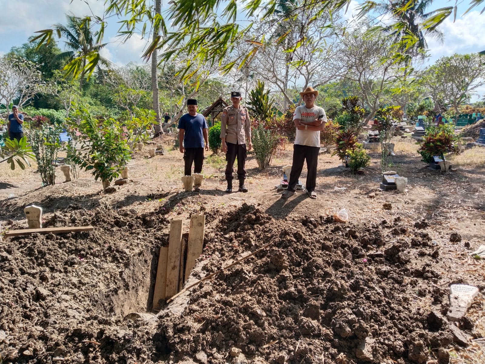 BURU PELAKU: Polisi dan warga mendatangi kuburan yang dibongkar orang misterius di Desa Plampangrejo, Kecamatan Cluring, Sabu lalu (29/6).