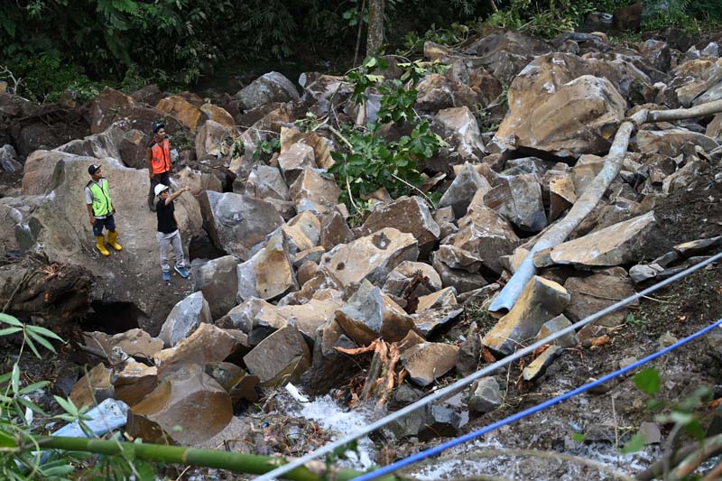 PUTUS: Bebatuan besar dari perbukitan di Kalongan, Desa Pesucen, longsor hingga menimpa pipa milik PUDAM sepanjang 100 meter pada Kamis &nbsp;(4/7).