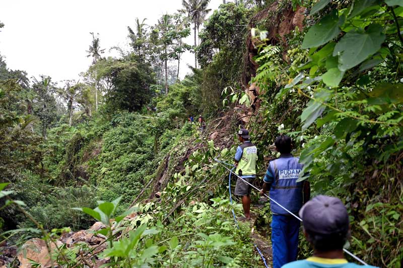 PERBAIKI PIPA: Pekerja PUDAM menarik tampar dan seling dalam proses perbaikan pipa di Kalongan Jumat (5/7).