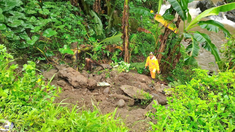 TINJAU LOKASI: Anggota TRC BPBD Kabupaten Banyuwangi Wilayah Kalibaru mengecek tanah yang longsor di sekitar Jembatan Bukjetem di Desa Banyuanyar, Kecamatan Kalibaru Minggu (7/7).
