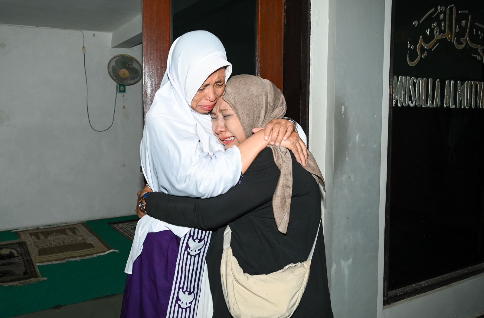 MENANGIS HARU: Ani Mintarti disambut keluarganya dengan pelukan haru. Warga Perumahan Kebalenan Baru 1 itu pulang tanpa didampingi suaminya, Muh. Ruslan, karena meninggal di Makkah.