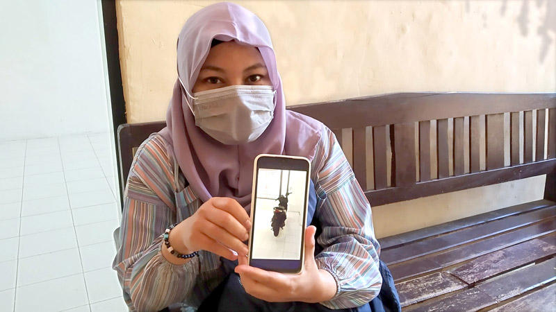 BARANG BUKTI: K alias Kinanti Indah Purwitasari menunjukkan foto motor Honda Beat miliknya yang berhasil diamankan di kantor Polsek Genteng Senin (8/7).