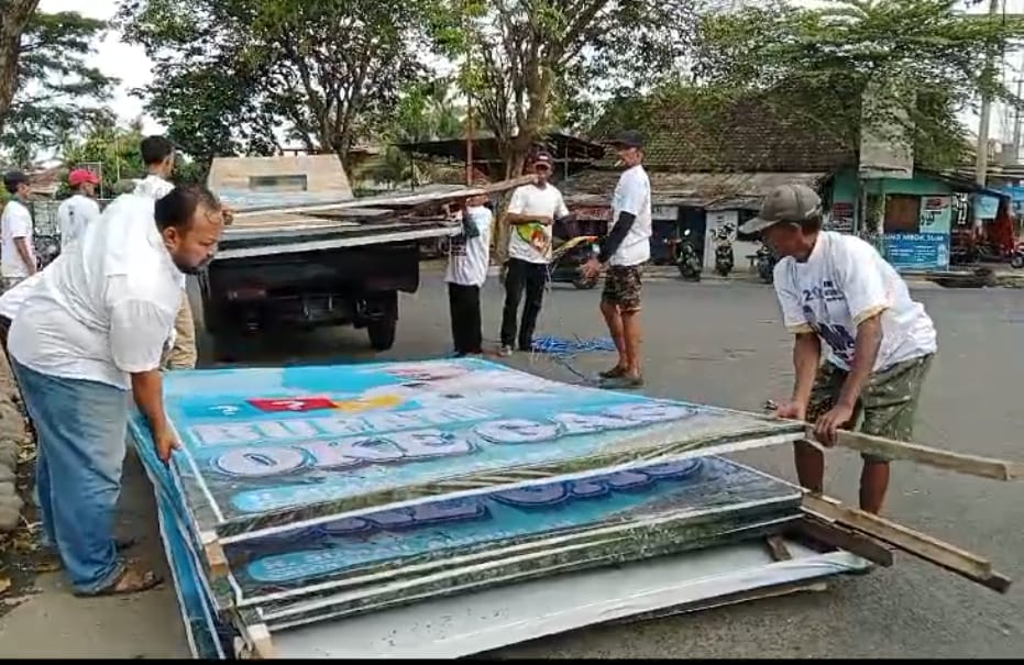 LAMPIASKAN KEKECEWAAN: Relawan Sumail Abdullah mencopoti banner di Lingkungan Brak, Kelurahan Kalipuro, Rabu lalu (10/7).