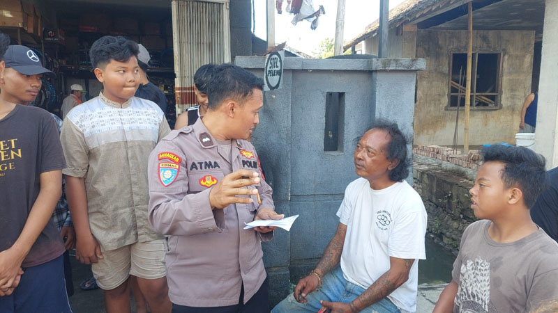 BERI PENJELASAN: Heri Murcahyono (baju putih) memberikan keterangan kepada anggota Polsek Genteng terkait kebakaran yang terjadi di rumahnya Kamis (11/7).