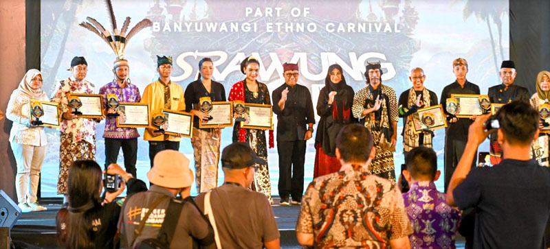TAMU KEHORMATAN: Bupati Ipuk Fiestiandani didampingi Sekkab Mujiono menyerahkan piala dan piagam penghargaan kepada perwakilan 12 delegasi peserta Srawung Seni di Gesibu Blambangan pada Jumat (12/7)