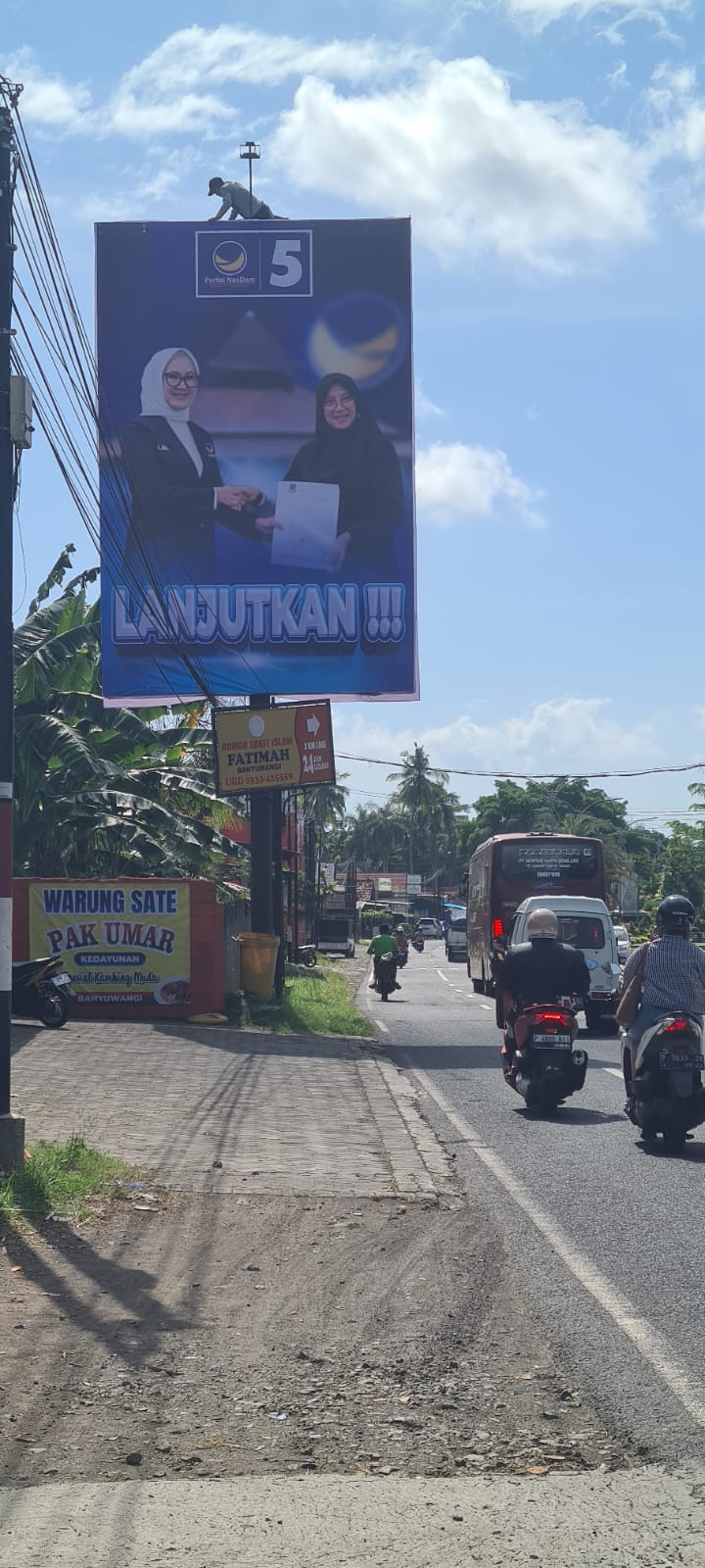 LANJUTKAN: Baliho bergambar Ipuk menerima rekomendasi cabup dari Ketua DPW NasDem Jatim Lita Machfud Arifin terpampang di pinggir jalan raya Kedayunan, Kabat, Senin (15/7).