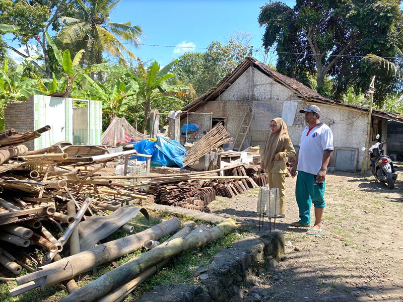 RATA TANAH: Kepala Dusun Purwosari, Desa Benculuk, Kecamatan Cluring, Krisnawati meninjau rumah Murisnowati yang ambruk akibat diterjang angin Selasa (16/7)