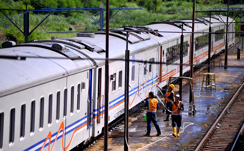 Para pekerja membersihkan gerbong kereta di Ketapang. Jika tol Probowangi tersambung ke Banyuwangi, PT KAI akan kena dampak.