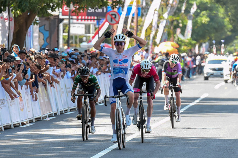 SELEBRASI: Pembalap Australia Ryan Cavanagh dari Kinan Cycling Team Jepang menyentuh garis finis dengan catatan waktu 2 jam 45 menit 28 detik.