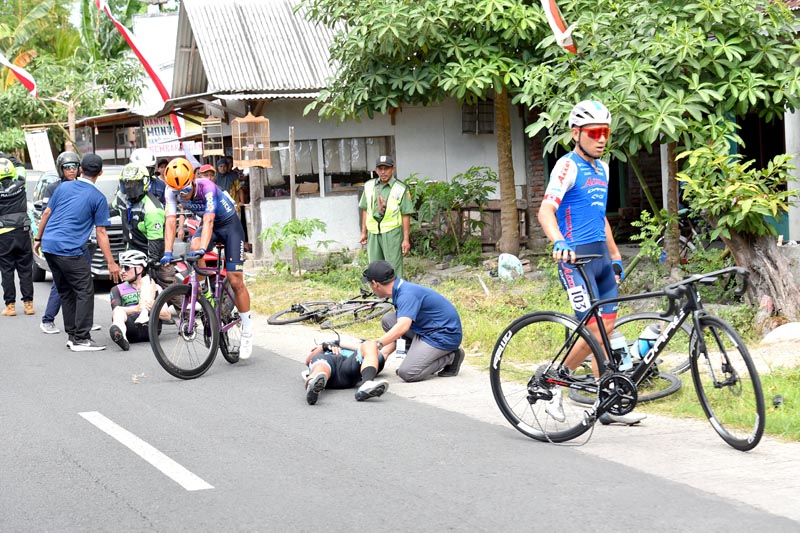 TERJATUH: Dua pembalap, Ryan Chilt dari CCACHE X Par K&uuml;p Australia dan Sanjin Choi dari tim LX Cycling Team Korea Selatan terjatuh di Kedungasri, Tegaldlimo.