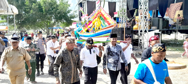 RITUAL TAHUNAN: Para nelayan memikul gitik sesaji menuju lokasi upacara ritual petik laut di pelabuhan Grajagan Rabu (24/7)