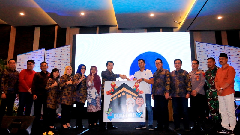 SIMBOLIS: Hendra Sutedja selaku pemegang saham BPR ADY Banyuwangi menyerahkan plakat hadiah umrah kepada perwakilan nasabah Umi Kulsum asal Dusun Jajangsurat, Desa Karangbendo, Kecamatan Rogojampi.