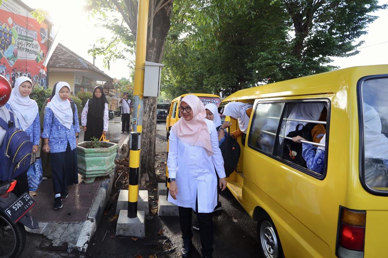 FINISH: Begitu turun dari angkot, Ipuk menyapa para pelajar didepan SMP 3 Muhammadiyah Banyuwangi .