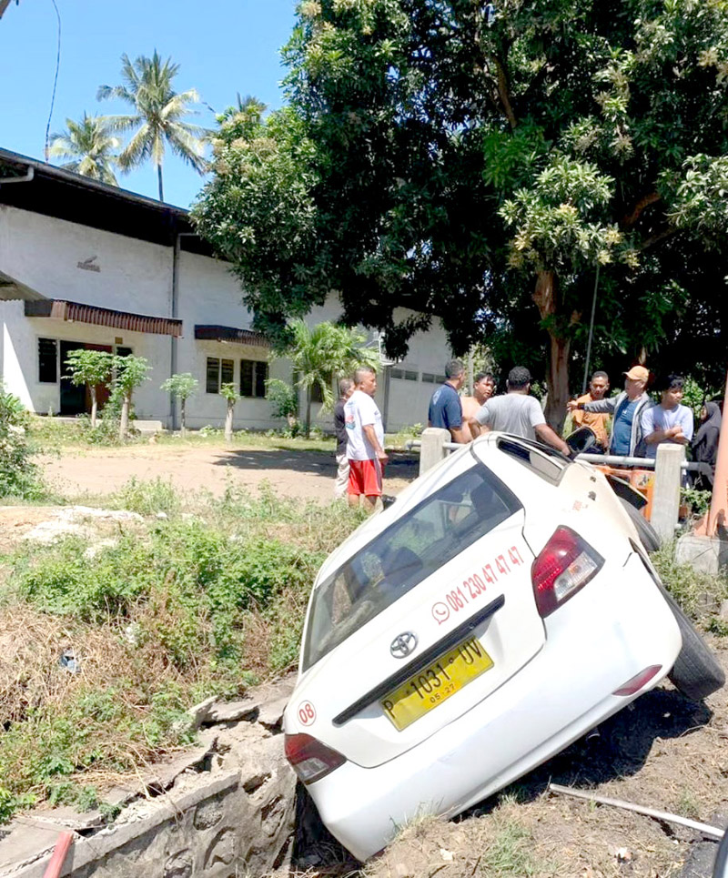 TERPEROSOK: Taxi yang dikemudikan pria berinisial A terperosok di selokan Jalan Raya Situbondo Selasa (6/8).