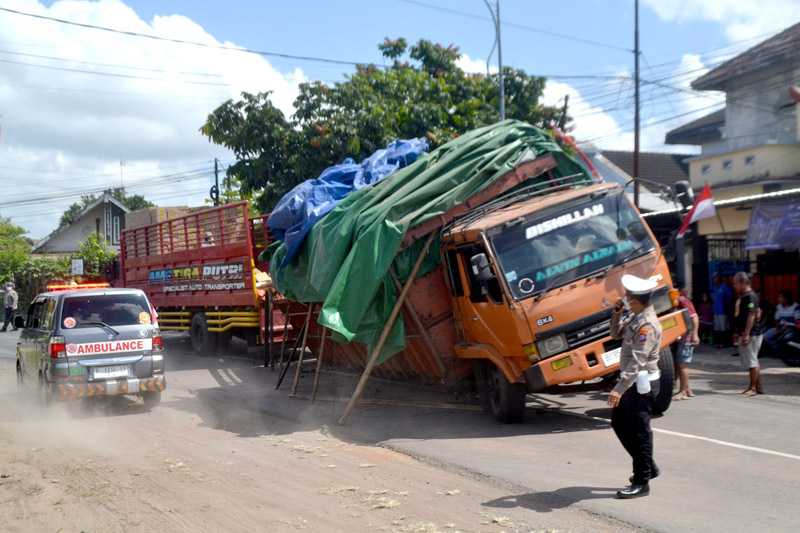 BIKIN MACET: Anggota unit lantas Polsek Rogojampi mengatur arus lalu lintas di jalan menikung Desa Lemahbang Kulon, Kecamatan Singojuruh Senin (12/8)