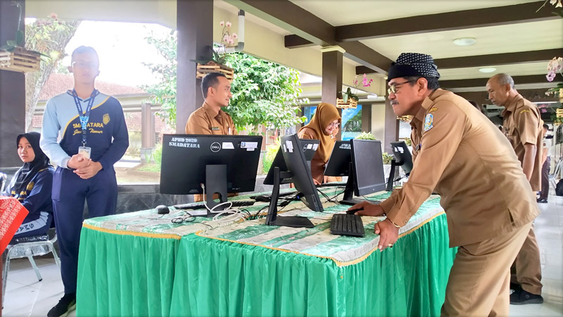 DIGITALISASI: Kepala Smadatara Mujib (kanan) memberikan hak suaranya dalam pemilihan kepengurusan OSIS, MPK, dan Resimen di Lobi Smadatara, Desa Kembiritan, Kecamatan Genteng Senin (12/8).
