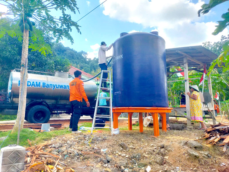 SUPLAI: Anggota BPBD dan warga mengisi air bersih di tendon berkapasitas 5.000 liter di Dusun Kebonrejo, Desa Kebondalem, Kecamatan Bangorejo Rabu (14/8).