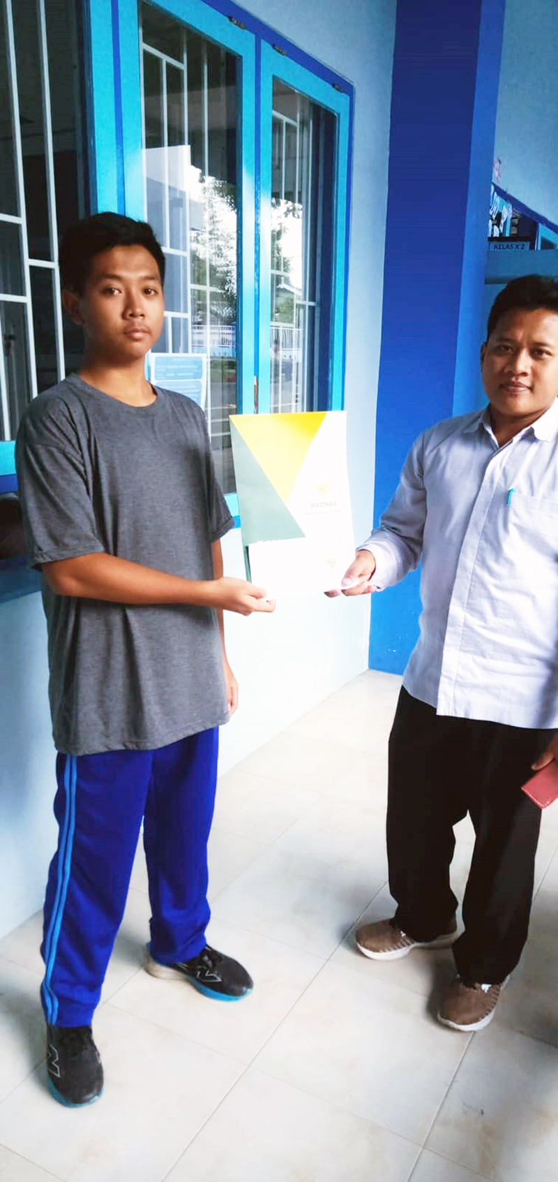 PEDULI PENDIDIKAN: Petugas Baznas menyerahkan bantuan kepada farhan di SMAN 1 Glagah.