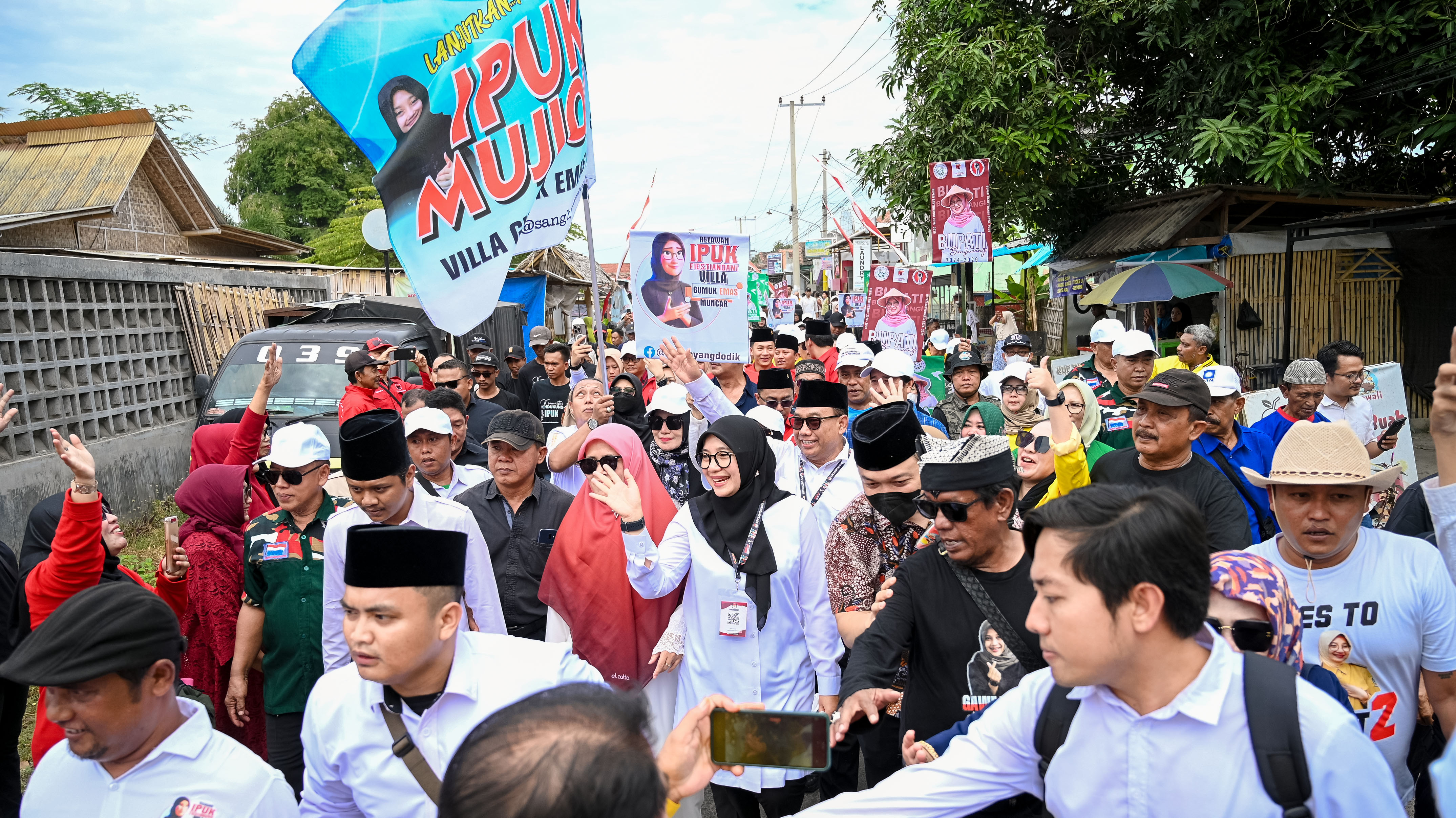 DAPAT SAMBUTAN HANGAT: Pasangan Ipuk-Mujiono berjalan kaki diiringi ribuan orang dari Posko Kebersamaan menuju kantor KPU Banyuwangi.