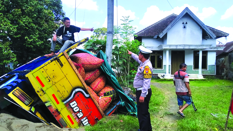 HINDARI PENYEBER Truk bermuatan cabai terperosok ke parit di jalan simpang tiga barat SPBU Krikilan, Dusun Krajan, Desa Tegalharjo, Kecamatan Glenmore Jumat (30/8).