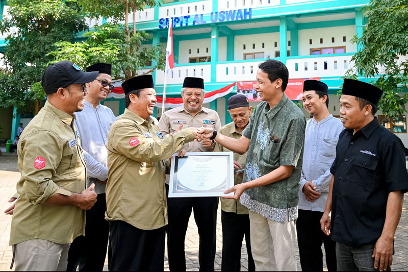 PILIHAN PEMBACA JP-RABA: Ketua Yayasan Al Uswah Karyono SPd MT menerima penghargaan cabup favorit yang diserahkan oleh General Manager Bayu Saksono di halaman SMPIT Al Uswah