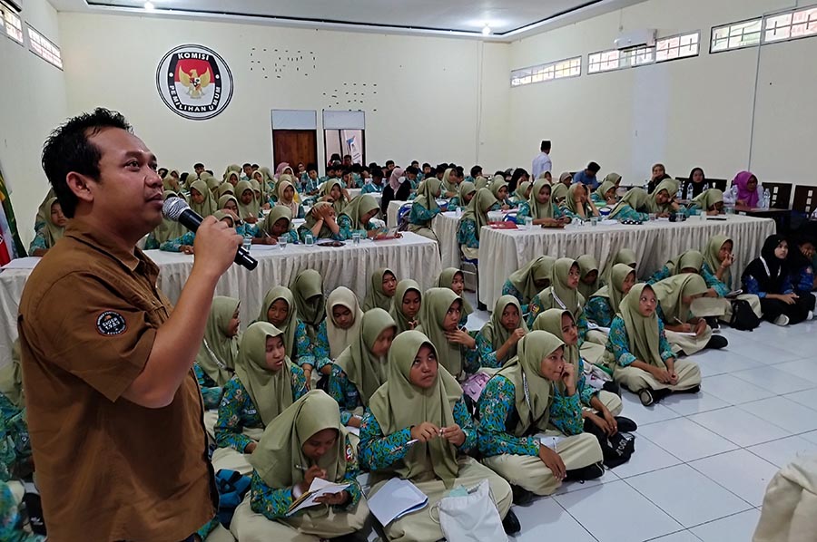 Komisioner Divisi Sosdiklihparmas-SDM KPU Enot Sugiharto (kiri) memberikan pendidikan demokrasi kepada para pelajar SMPN 2 Glagah di Kantor KPU Banyuwangi, Rabu (4/9).