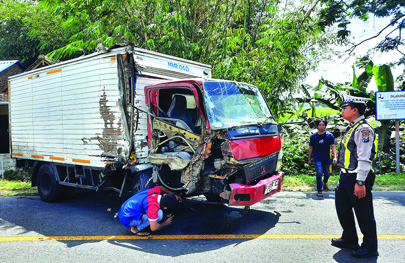 REMUK: Truk box milik Indomaret rusak berat disisi kanan usai tabrakan dengan truk fuso di jalan raya Desa Tulungrejo, Glenmore, Banyuwangi, Rabu (4/9).