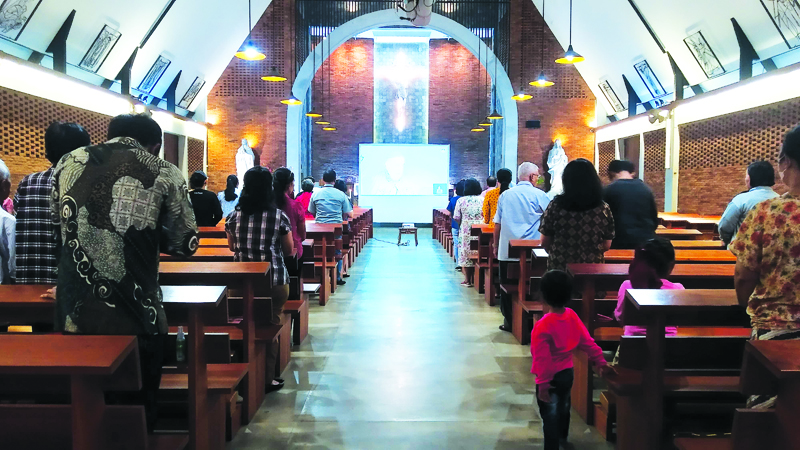 KHIDMAT: Umat Katolik mengikuti Misa secara virtual bersama Paus Fransiskus di Gereja Katolik Paroki Kristus Raja, Desa Genteng Kulon, Kecamatan Genteng Kamis (5/9).