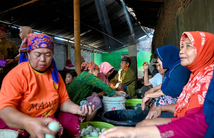BERDAYAKAN WARGA: Emak-emak membersihkan telur bebek di rumah Sai Bunawan di Dusun Jambean, Desa Jambesari, Giri, Senin (9/9).