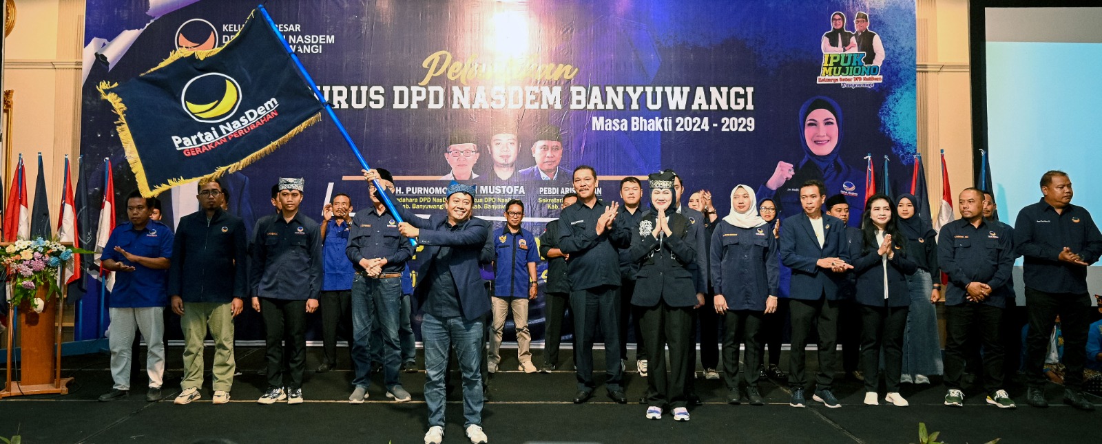 Ali Mustofa didampingi Ketua DPW NasDem Jatim Lita Arifin mengibarkan pataka usai dilantik sebagai ketua DPD NasDem masa bakti 2024&mdash;2029 di Hotel Aston Banyuwangi Kamis (12/9).